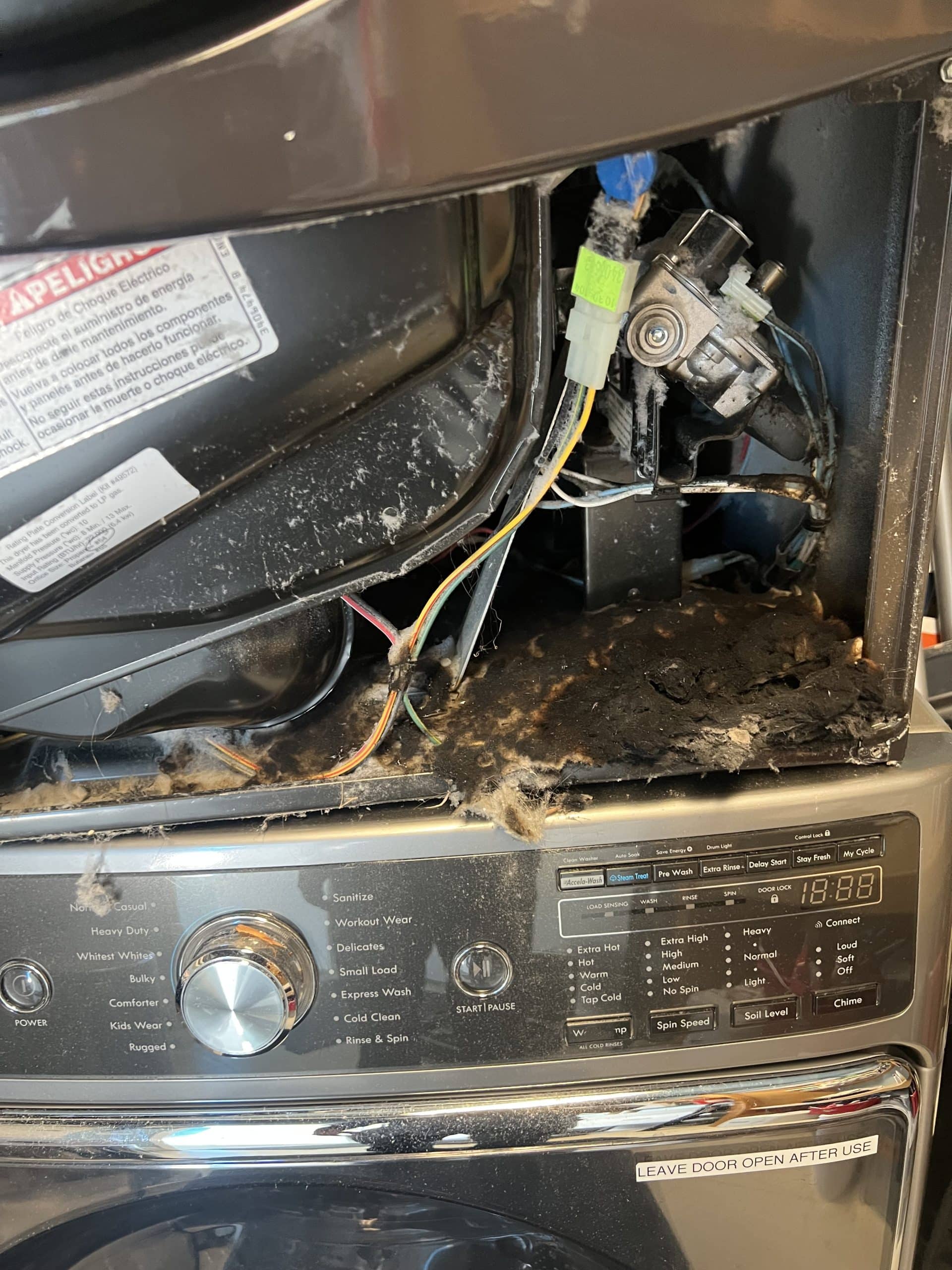 Washing machine with exposed internal wires and components.