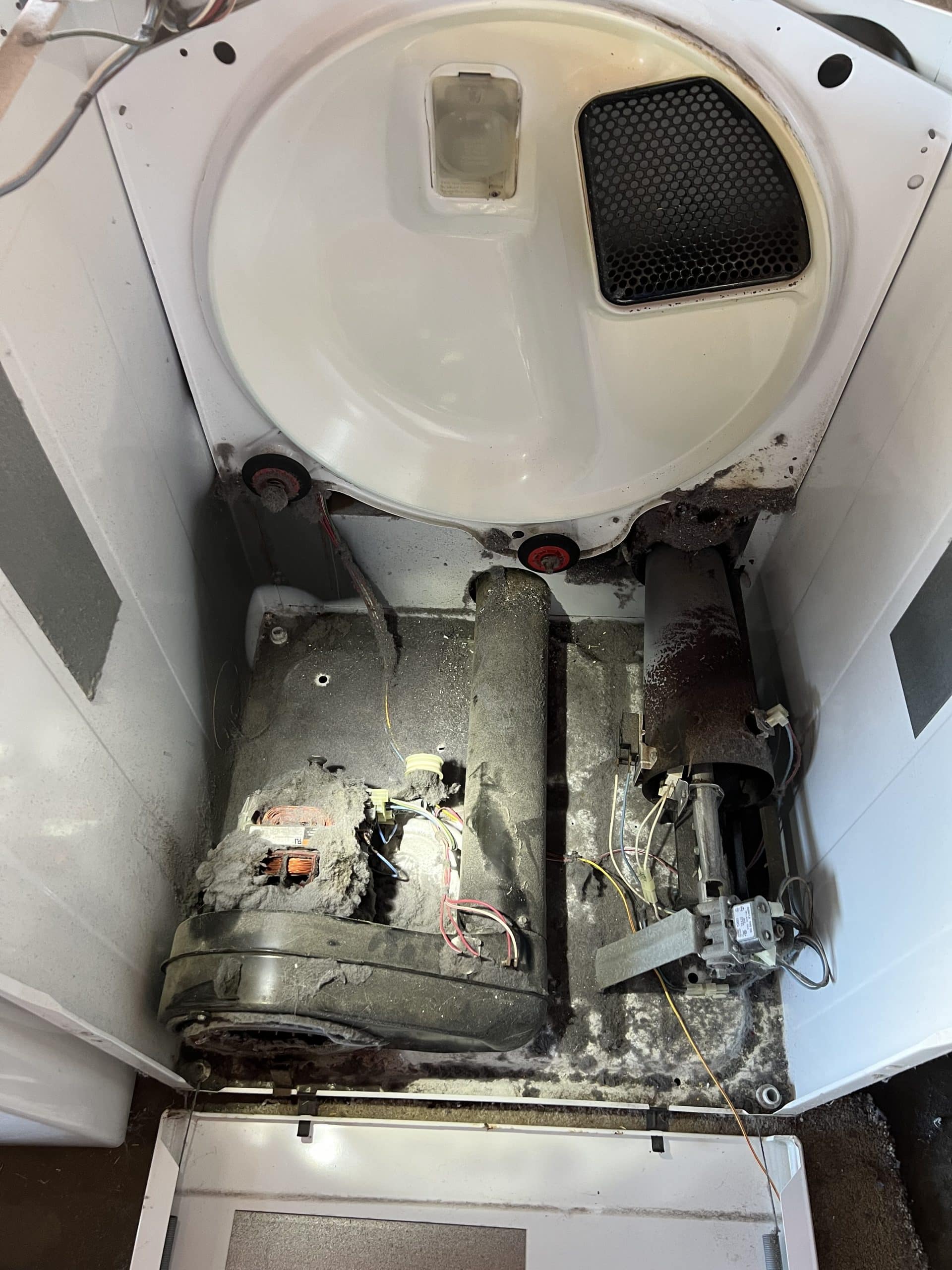 Open washing machine showing fire burned interior components.