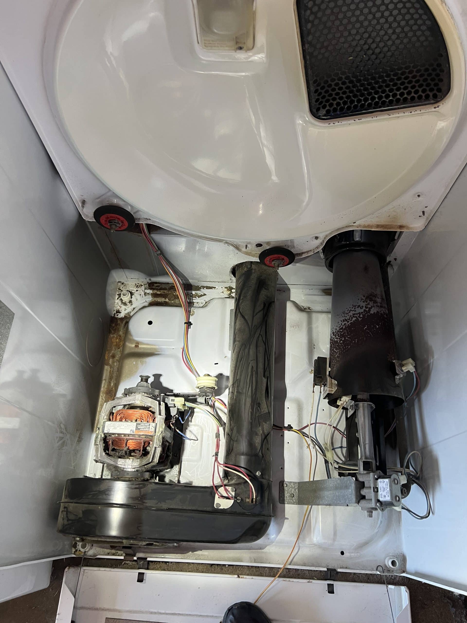 Washing machine interior with motor and wiring replaced after fire.