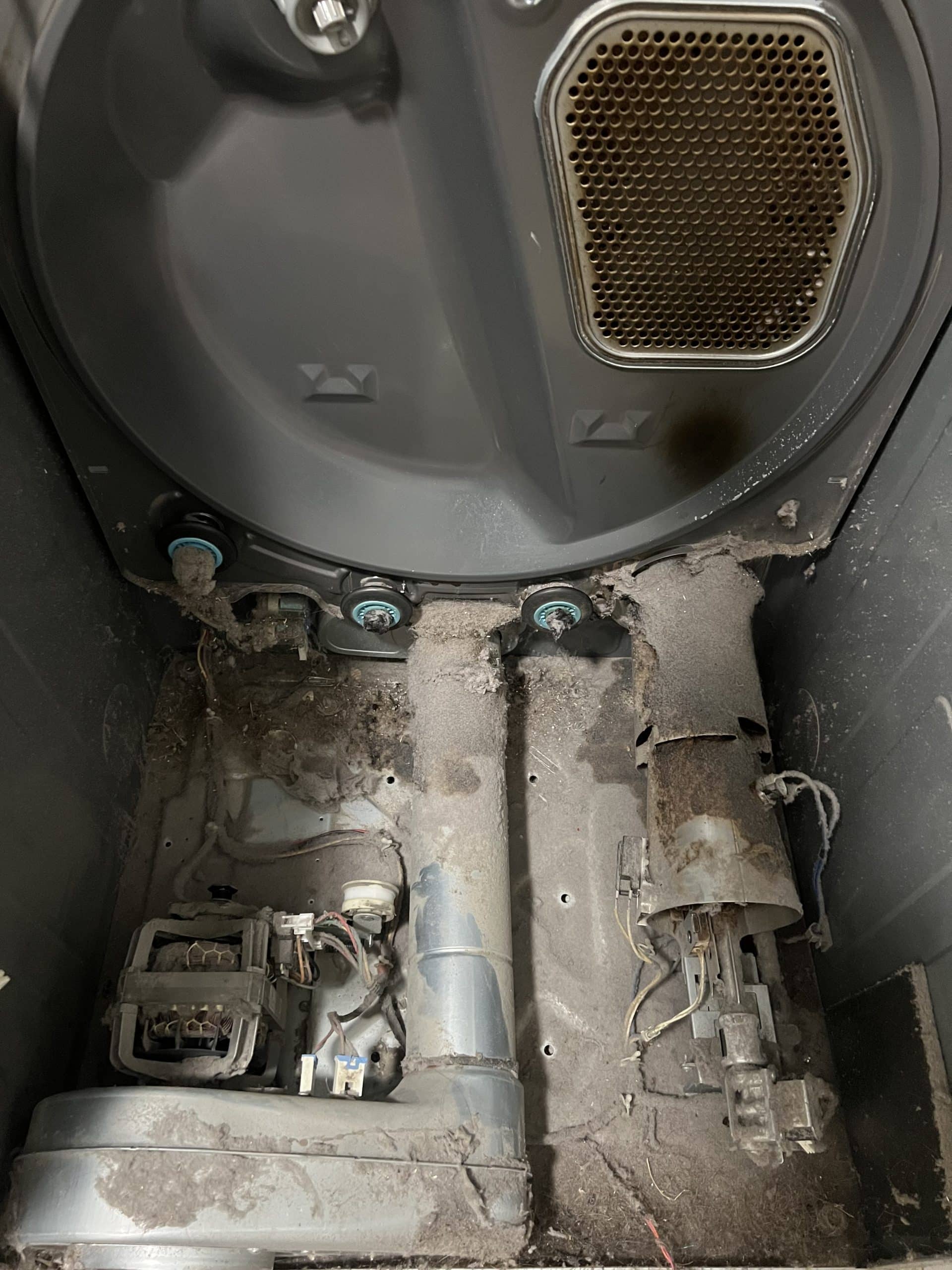 Dusty interior of a washing machine's mechanical parts.