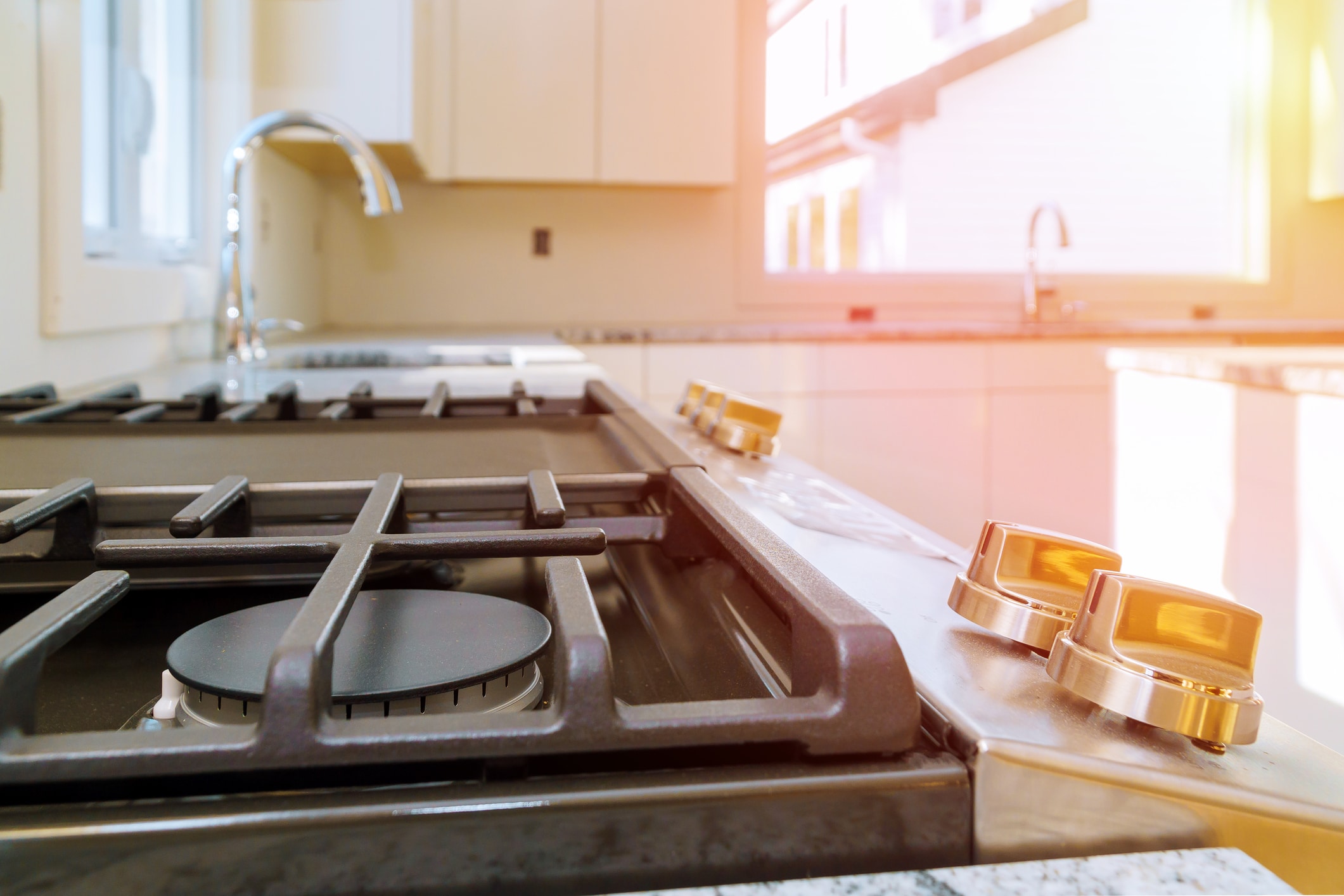 dreamstime_m_133887802 Modern kitchen stove with sunlight reflection