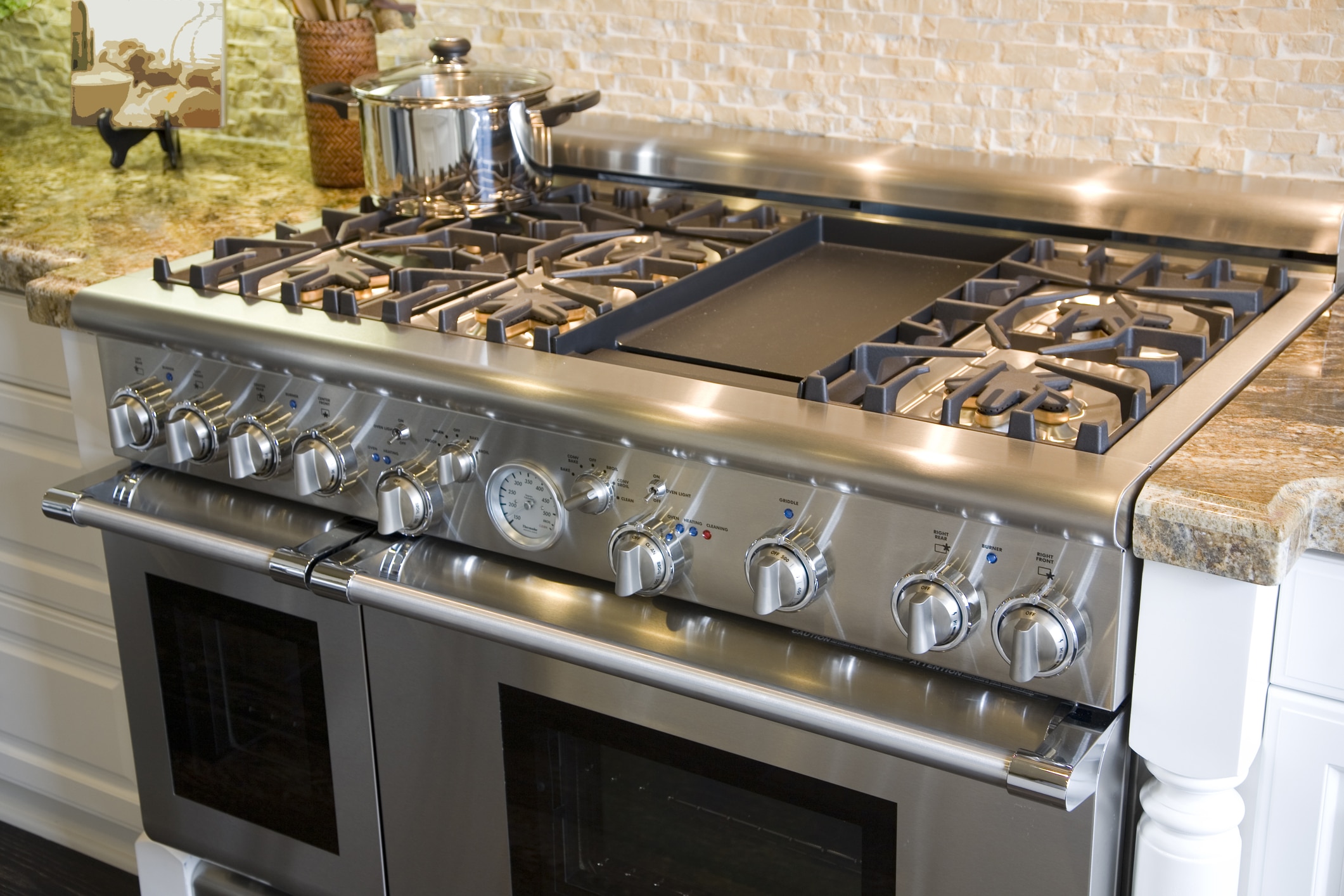 Stainless steel gas stove with multiple burners.