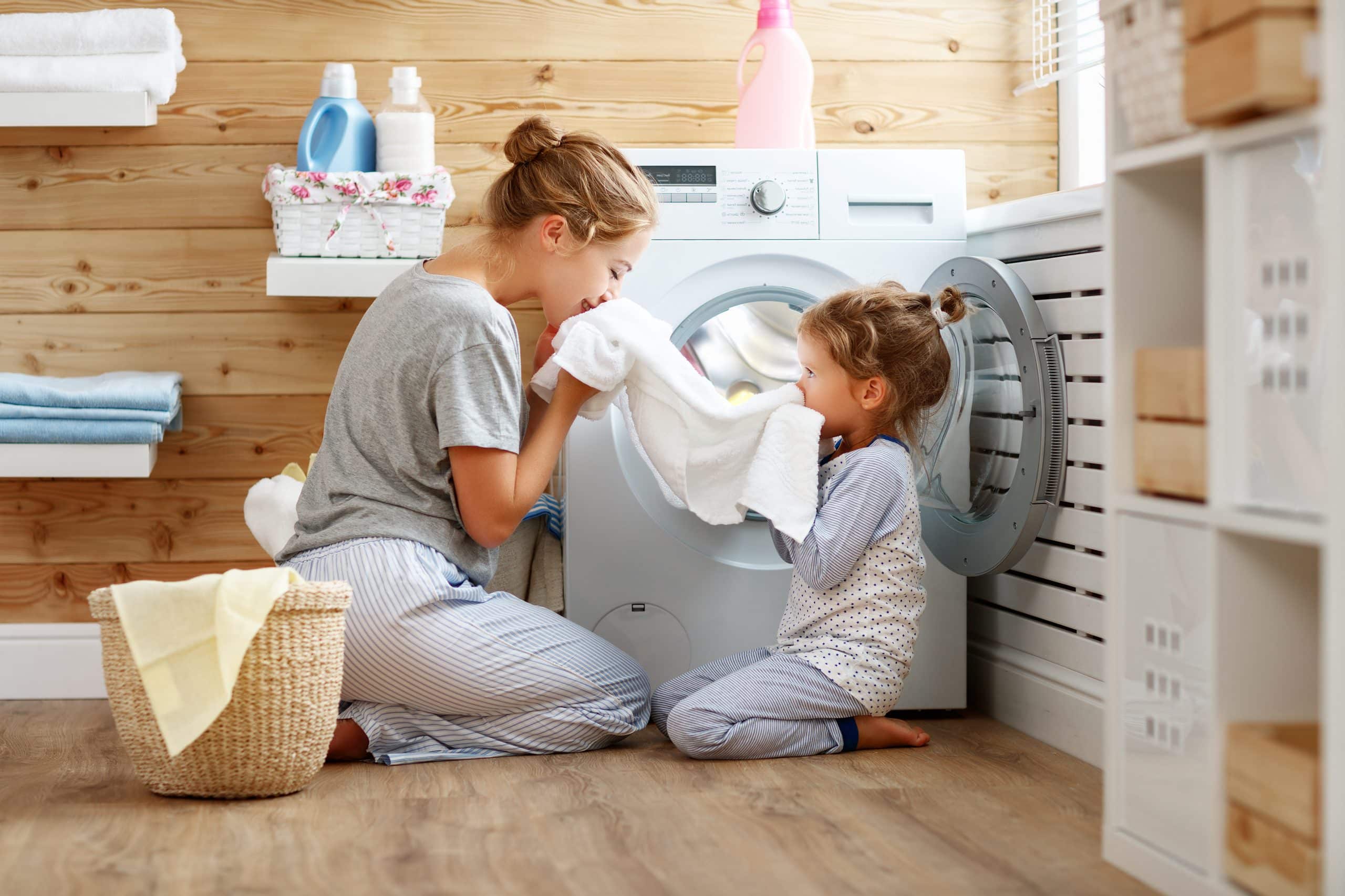 Mother and daughter doing laundry happily together