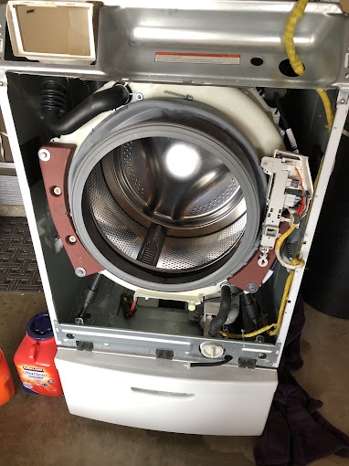 001 Open washing machine with exposed drum and detergent.